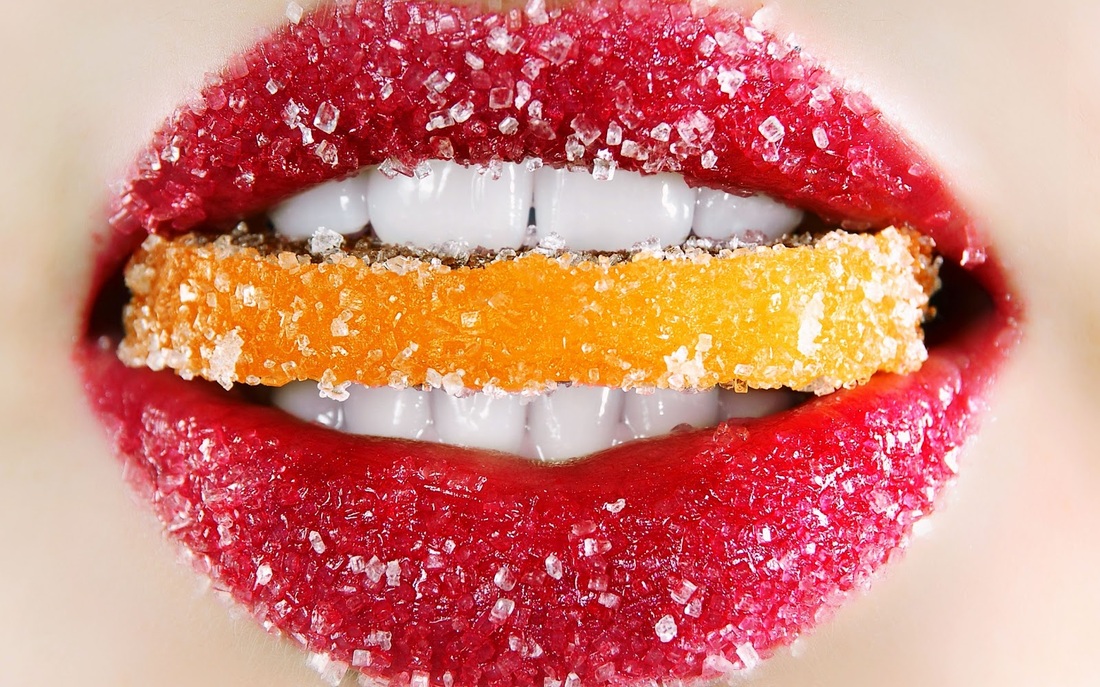 mouth with sugar-covered lips and a sugar covered orange peel